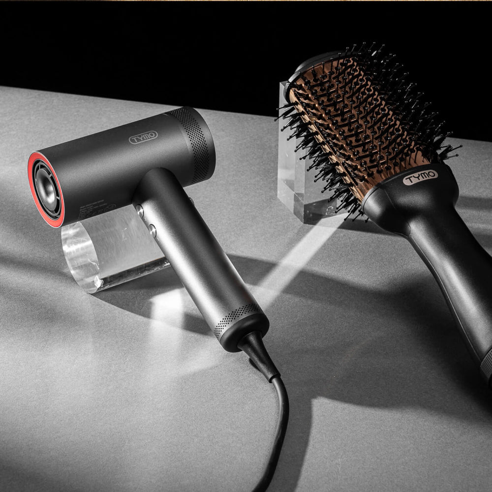 TYMO AIRHYPE hair dryer and TYMO VOLUMIZER brush presented, showcasing high-end tools for versatile hair styling.