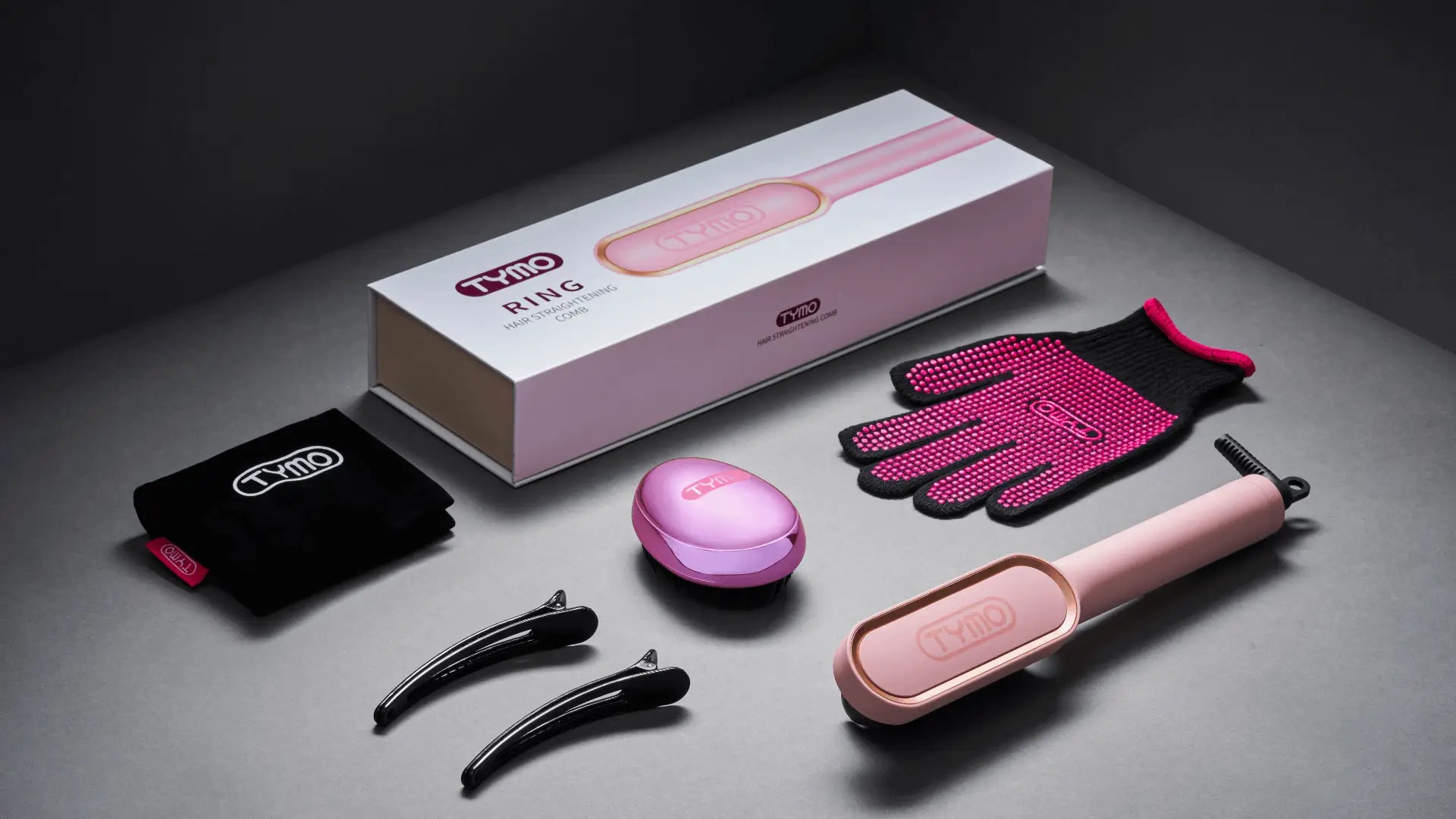 Complete set of TYMO RING PINK hair straightener with accessories including heat-resistant gloves, hair clips, travel case, and charging base.