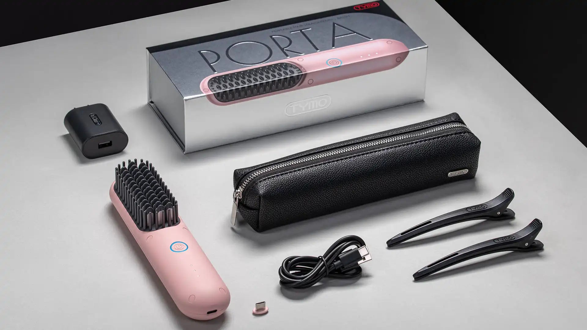 Packaging of TYMO PORTA PINK wireless hair straightener including brush, carrying case, USB cable, and accessories.