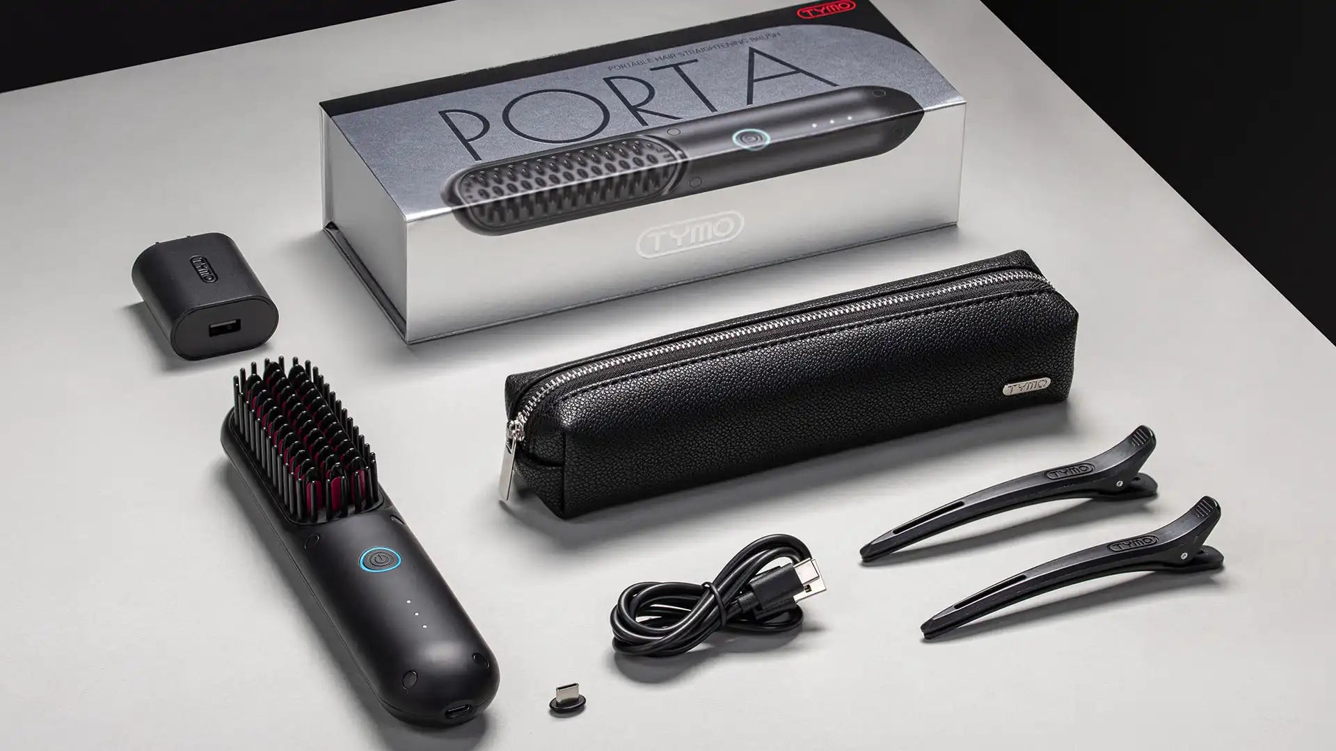 Complete packaging of TYMO PORTA cordless hair straightener with accessories including USB cable and travel pouch.