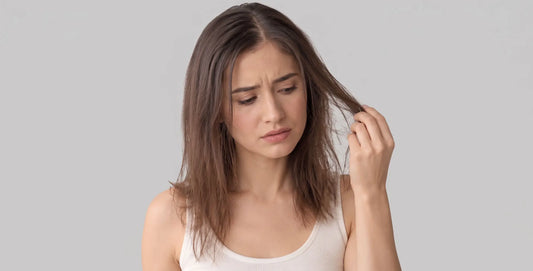 Woman with fine, flat hair looking frustrated and checking hair texture before styling for volume.