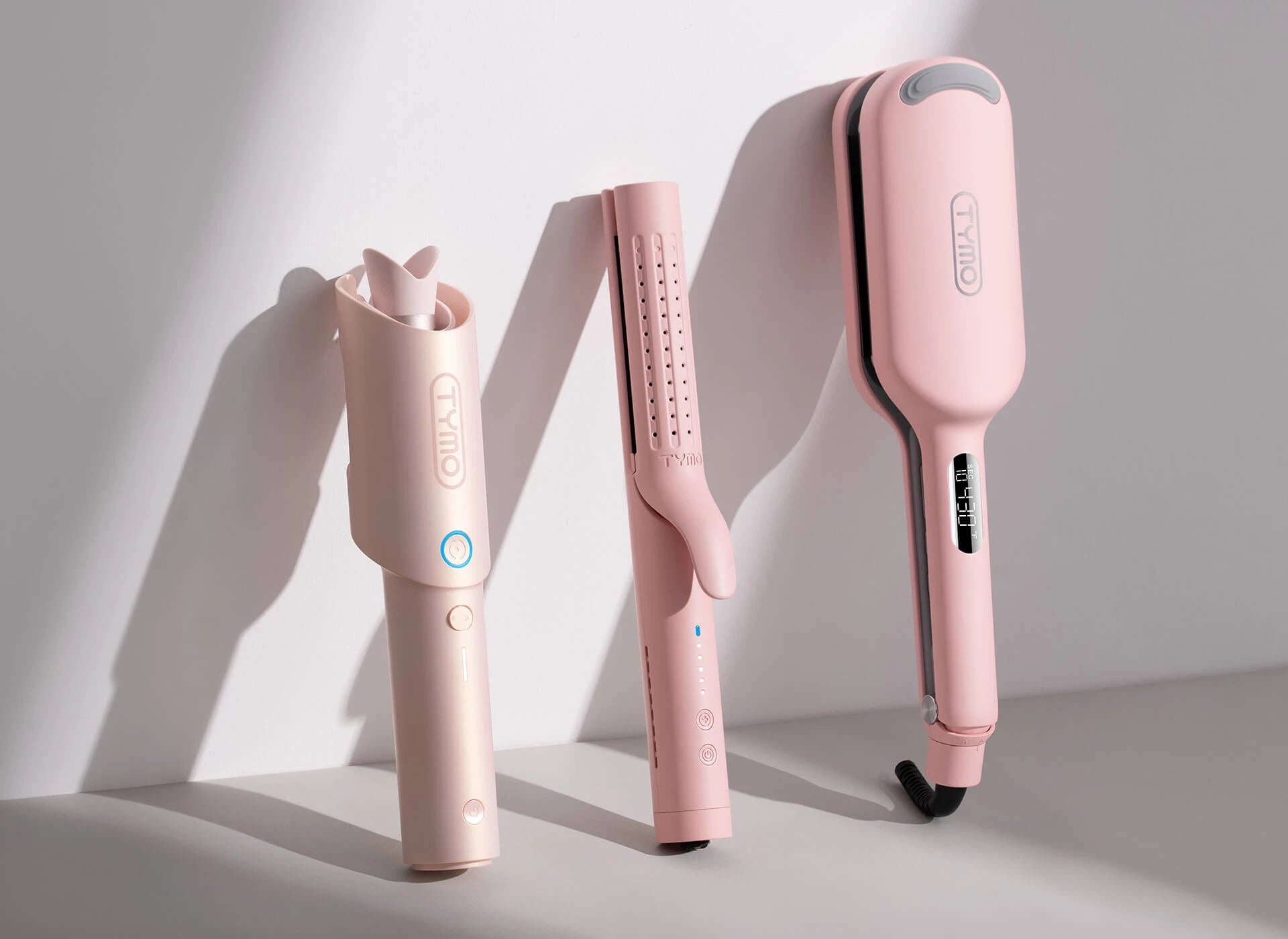 Three distinct TYMO hair curlers are presented side by side, illustrating the variety of curling options for different hair types and styles.