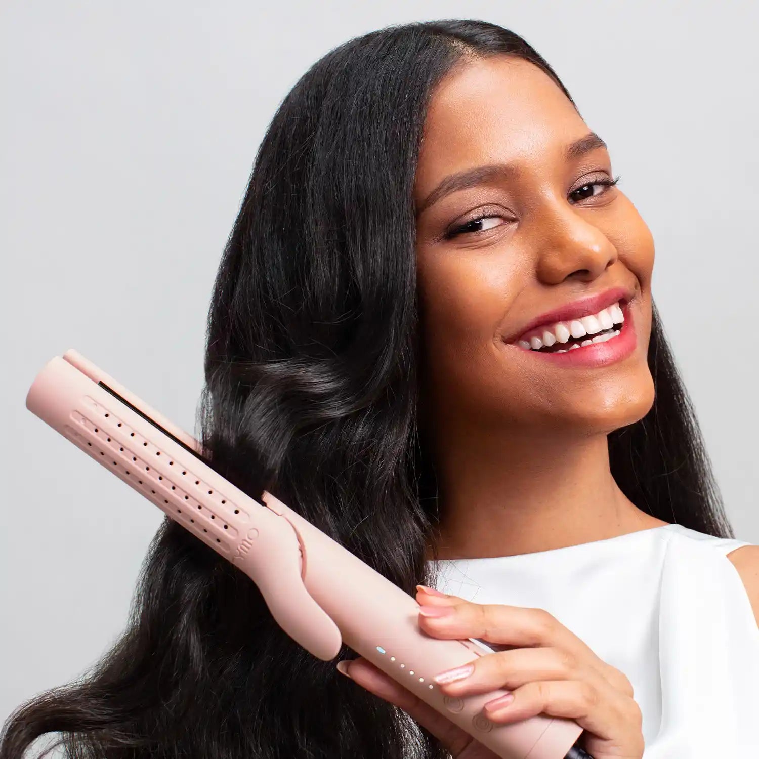 Happy woman using the TYMO AIRFLOW PINK hair curlers to achieve beautiful curlers.