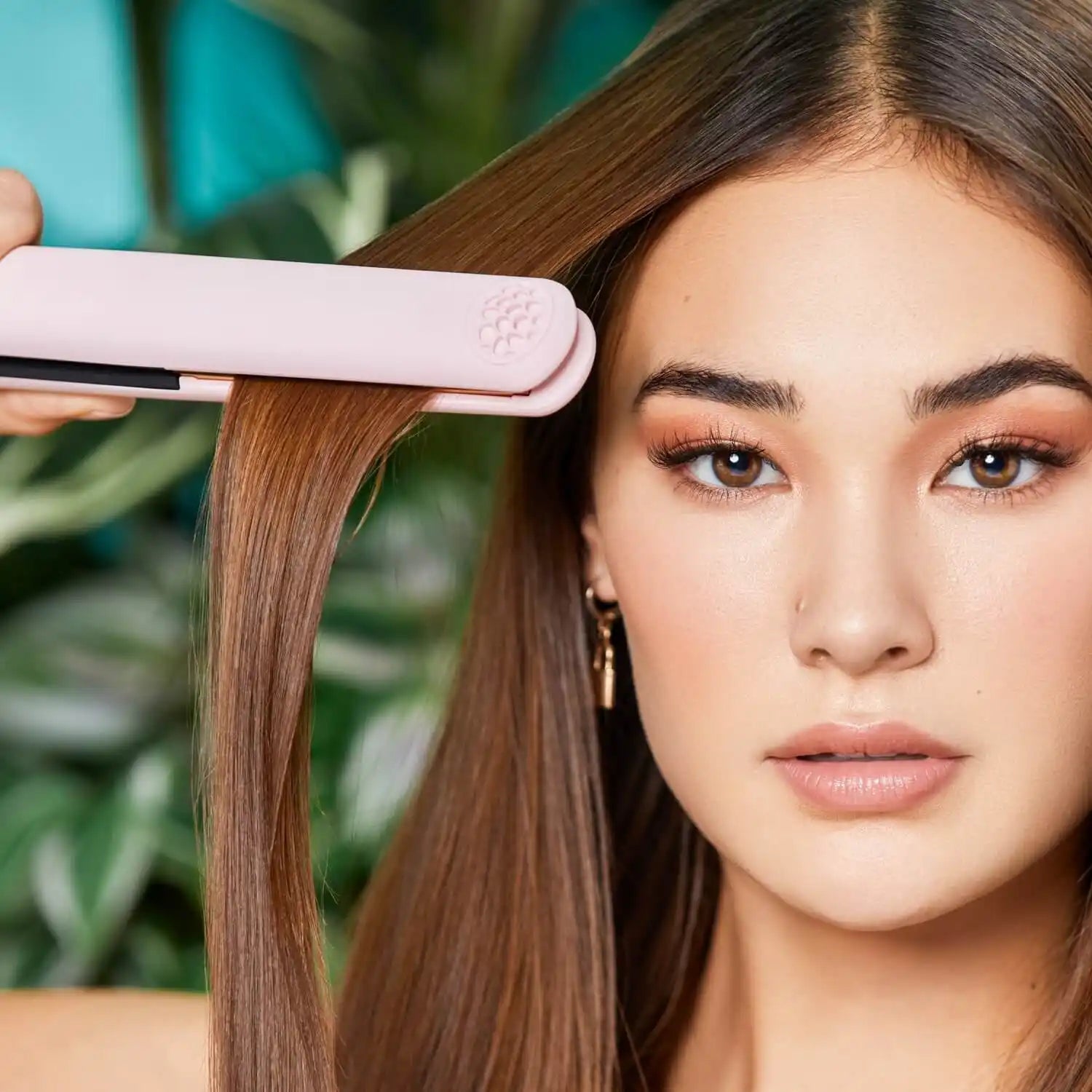 Close-up of a TYMO SWAY hair straightener flat iron being used by a young woman, highlighting its ergonomic features.